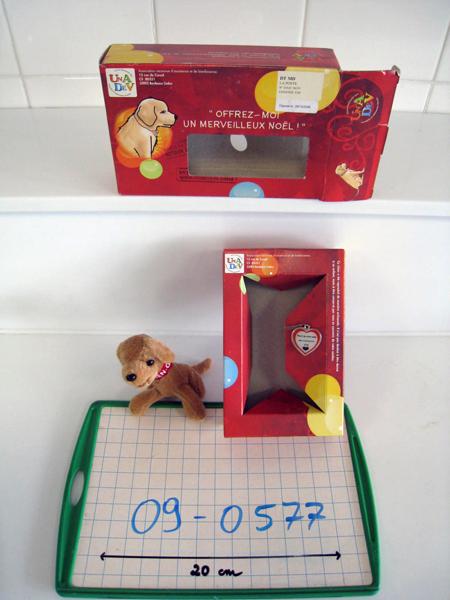 Soft toy puppy with a collar marked "Offrez moi un merveilleux Noël" ("Give me a wonderful Christmas")